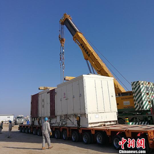圖為現(xiàn)場正在吊裝電氣柜。(李雪冰攝)