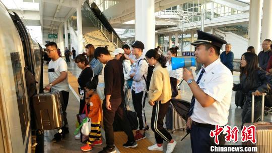 圖為商丘車站，工作人員在站臺(tái)引導(dǎo)旅客乘降。　趙晶晶 攝