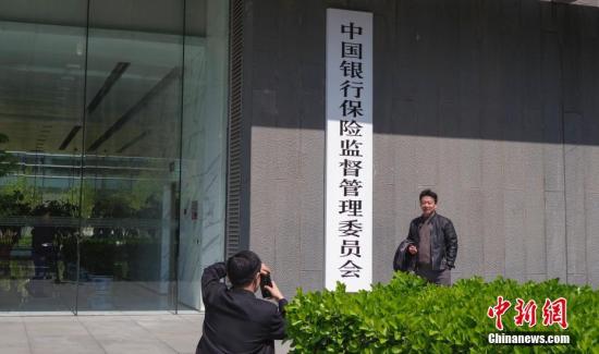 4月8日，中國銀行保險監(jiān)督管理委員會在北京正式掛牌，民眾與新牌合影。中新社記者 賈天勇 攝